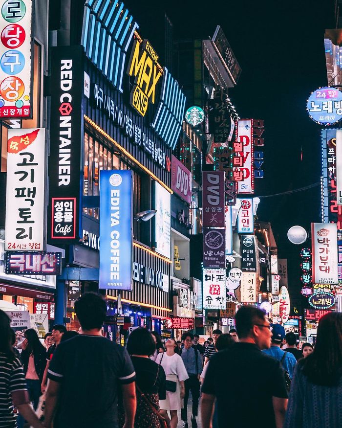 Busy Seoul street at night filled with colorful neon signs and crowds, captured by a US expat English teacher.