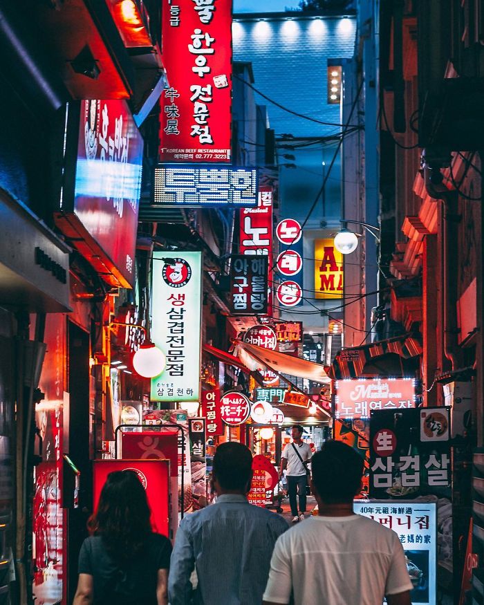 Night street scene in Seoul filled with colorful signs and people walking, showcasing vibrant city life in Korea.