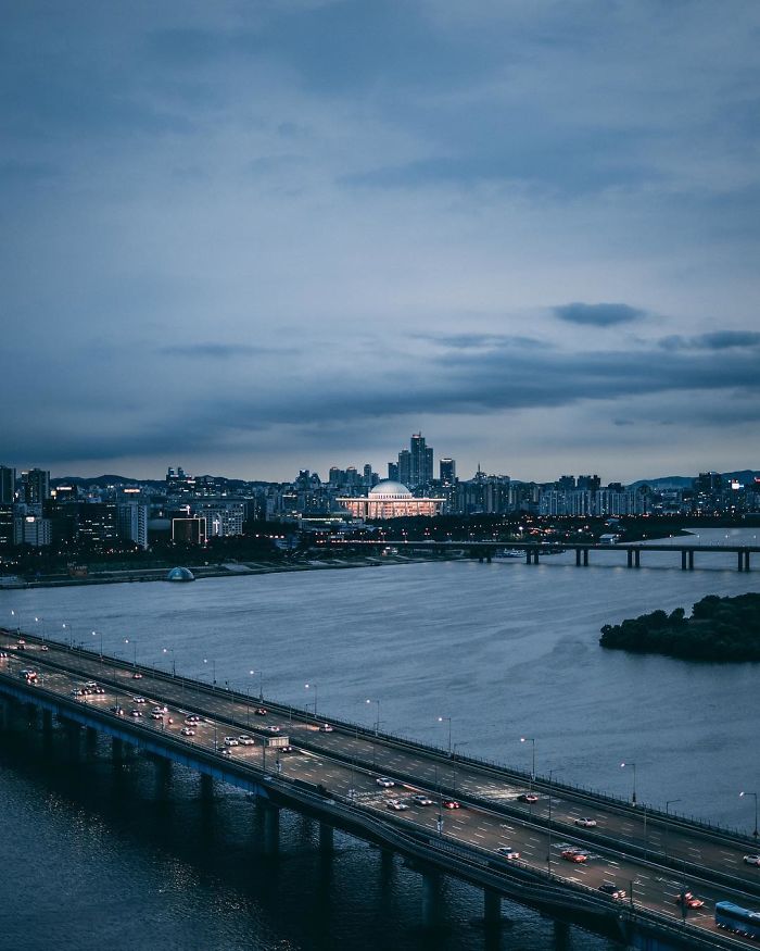 Evening cityscape of Seoul featuring a lit bridge over the river, highlighting views from an English teacher's photo collection.
