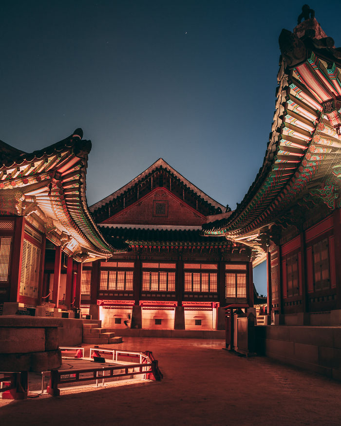 Traditional Korean buildings illuminated at night in Seoul, showcasing architecture captured by an English teacher living in the city.