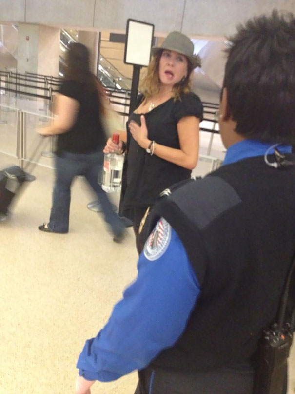 Woman At Dulles Security Line, Unable To Carry Her Plastic Handle Of Smirnoff Vodka Through Security, Is Currently Drinking It In Line And Offering Swigs To Other Passengers. It's 7:30 Am And TSA Is Not Amused