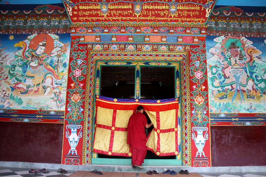 A Buddhist Monk Enters The Prayer Room Of Tharlam Monastery In Boudhanath, Nepal