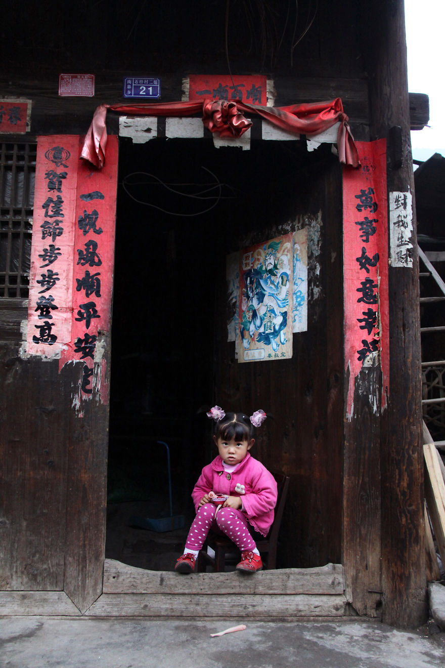 A Young Girl Is Posing At The Entrance Of Her House In Shiqiao, Guizhou Province, China