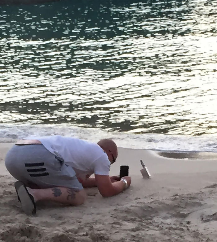 Hombre haciendo una foto de su vapeador en la playa