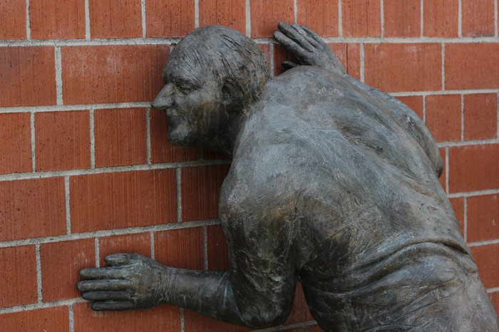 Statue imitating listen to wall
