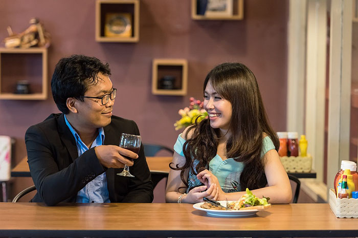 Couple eating and drinking in restaurant