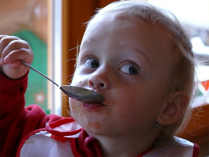 Kid eating with a spoon