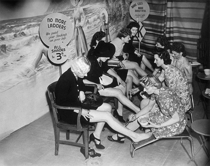 Pintando las piernas a las clientas para que parezca que llevan medias, Londres, 1941