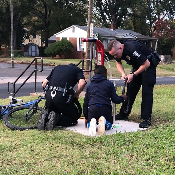 Two Officers Stopped To Help A Young Boy Change A Bike Tire After They Noticed He Was Struggling On His Own