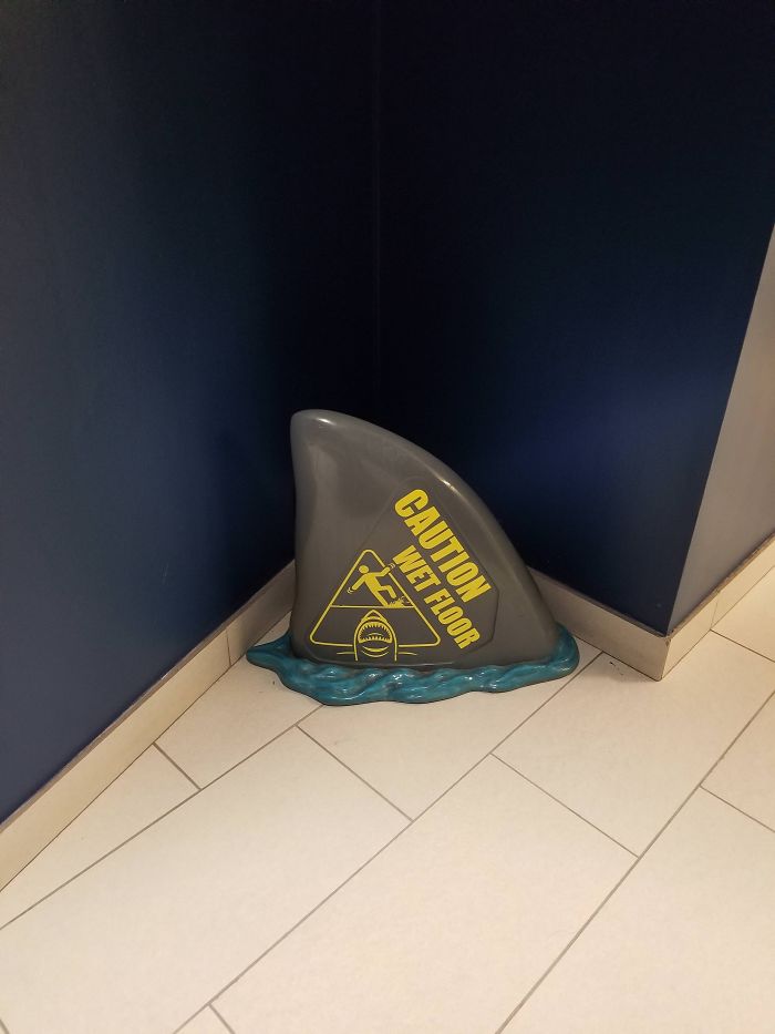 A Wet Floor Sign In The Shape Of A Shark Fin
