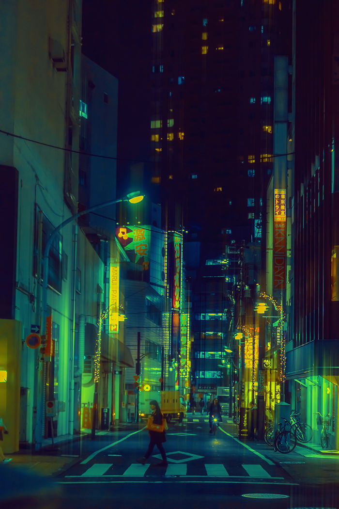 Tokyo street scene at night with neon signs and people walking, captured during a dream trip photography session.