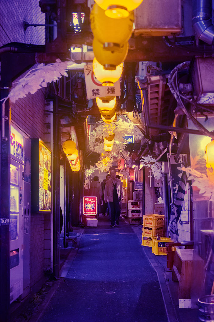 Night street in Tokyo with glowing yellow lanterns and pedestrians, captured during a dream trip photography session.
