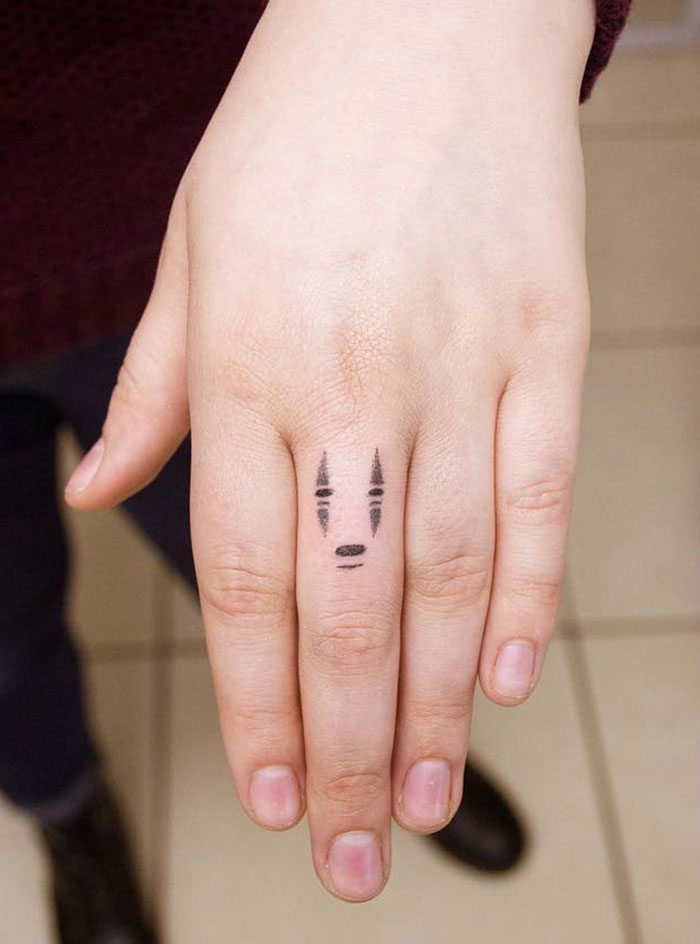 Tiny No Face Finger Tattoo