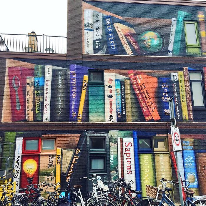 Estos artistas holandeses pintaron una librería gigante en la pared de un edificio, con los libros favoritos de los residentes
