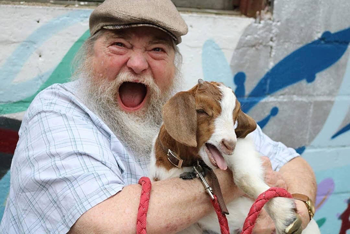 Son Shares Heartwarming Pictures Of His Dad Holding A 3 Weeks Old Baby Goat, And It's Priceless
