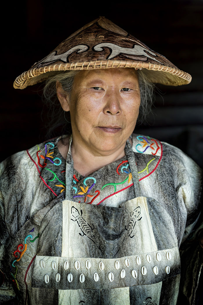 Indigenous woman wearing traditional embroidered clothing and a decorated woven hat in a remote corner of the world.