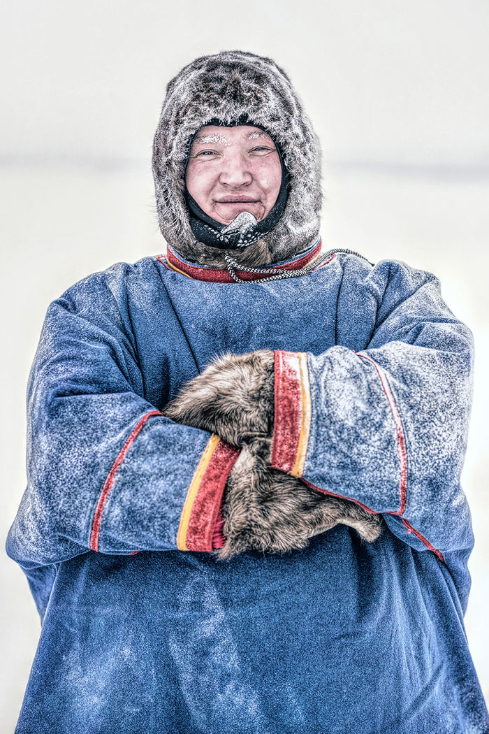 Indigenous person dressed in traditional fur-lined clothing, photographed in an inaccessible cold region of the world.