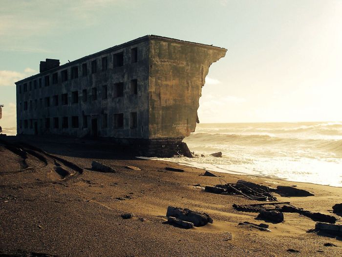 Edificio de pisos abandonado siendo reclamado por el mar, en el pueblo pesquero de Kirovsky, Rusia