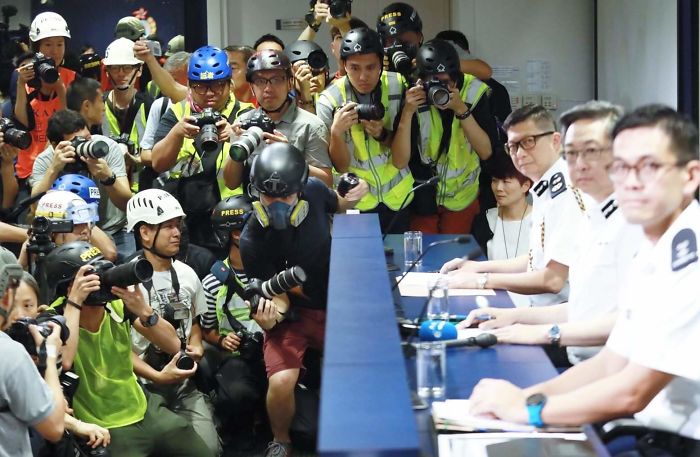 Los periodistas de Hong Kong llevan cascos, gafas protectoras y chalecos reflectantes para expresar su descontento con las acciones policiales