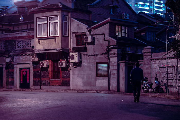 A quiet street at night featuring historic Shikumen lane houses with traditional architecture and modern air conditioners.