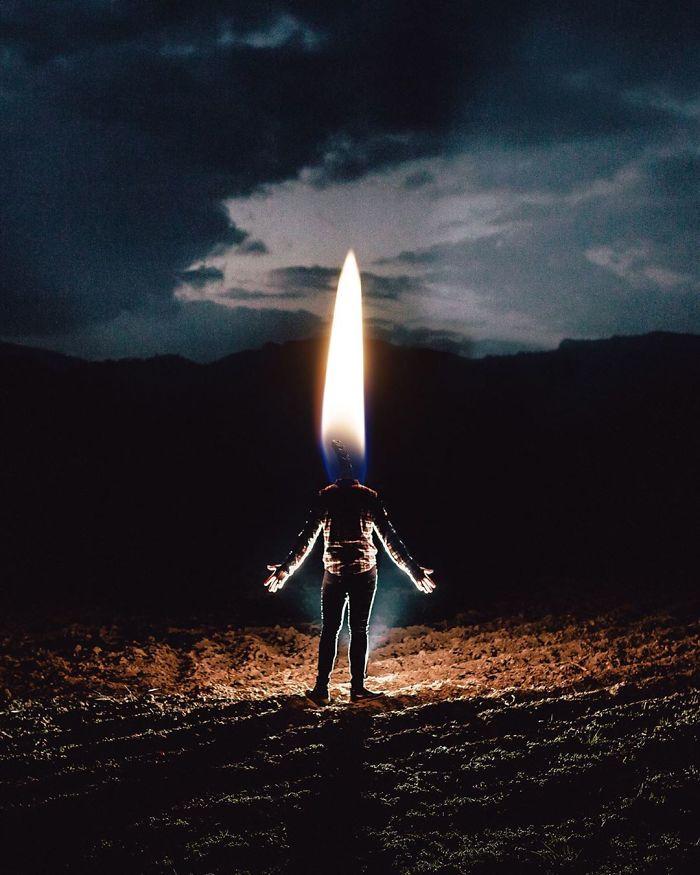 Surreal photo of a person standing in a field with a large flame as their head, creating a visual metaphor.