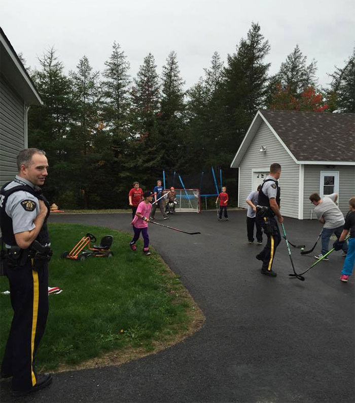 Police Playing Ball Hockey With The Neighborhood Kids. Just A Normal Day In Canada