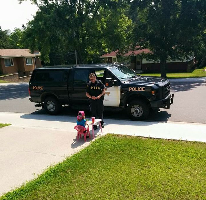 Police Officer Stops To Buy A Drink From A Little Girl At A Lemonade Stand In Kenora, ON, Canada