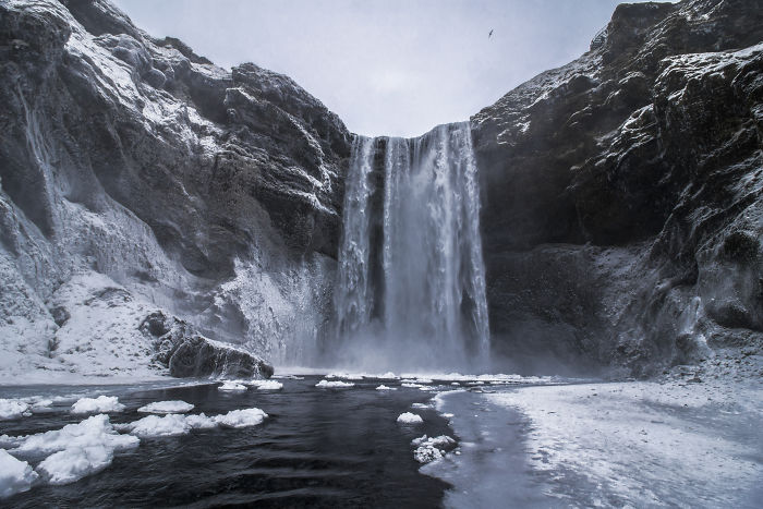 Iceland waterfall surrounded by snow and ice, capturing the natural beauty of Iceland's winter landscape.