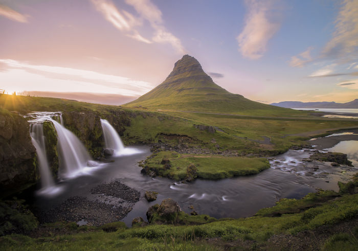 Waterfalls and Kirkjufell mountain in Iceland during sunset, showcasing the natural beauty of Icelandic landscapes.