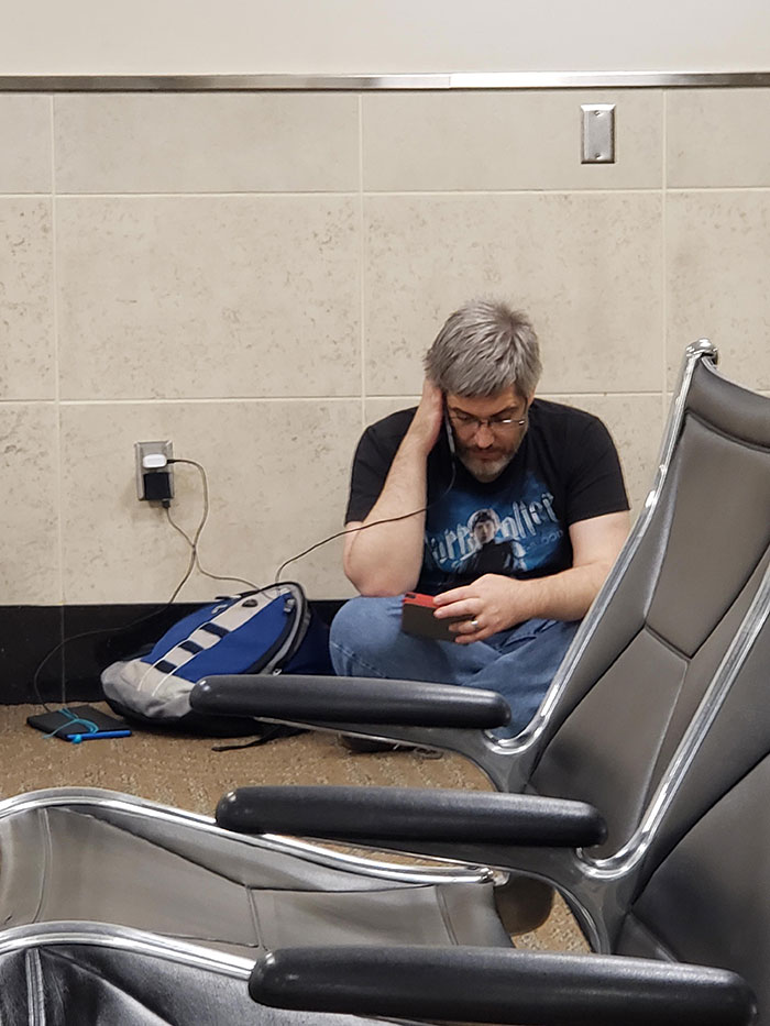 I Heard Soft Sound Of Reading Aloud (With Voices) At The Airport. This Man Is Reading The Lord Of The Rings To His Children. I Hope To Be That Kind Of Parent Someday