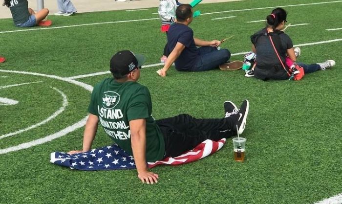 Brags About Standing For Anthem. Sits His Ass On Flag