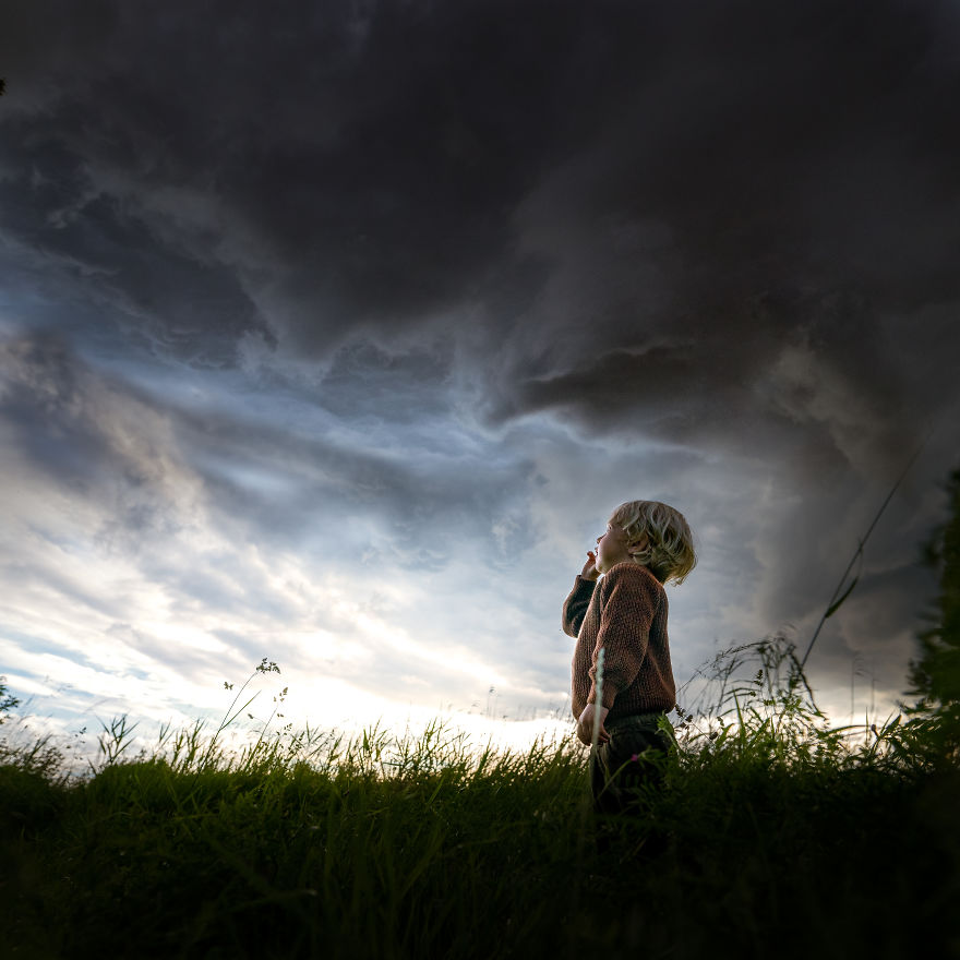 Niel, Belgium- A Boy Looking At A Stromy Sky