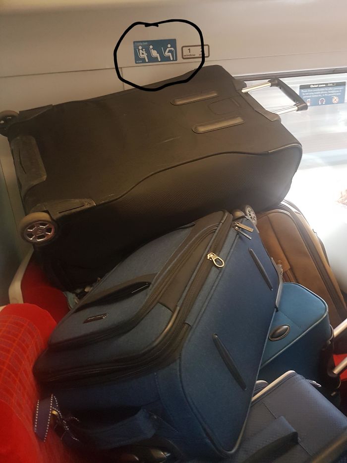 Bunch Of Luggage Piled Up On Priority Seats Of A Full Train