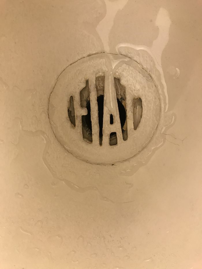 The Shower Drain In My Motel Room Is A Fiat Badge