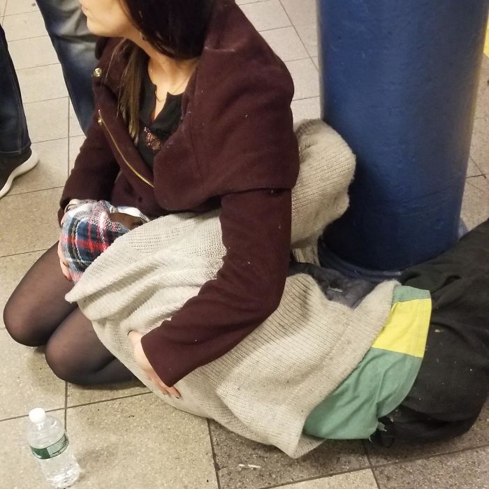 Woman Holds And Comforts A Homeless Man Experiencing Medical And Emotional Distress On The Subway Platform Until EMS Arrives
