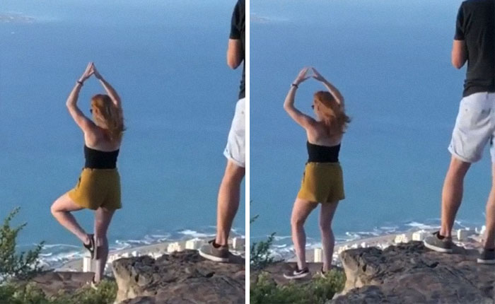 Woman posing for influencers in the wild on a cliff edge with ocean views, wearing black top and yellow shorts.