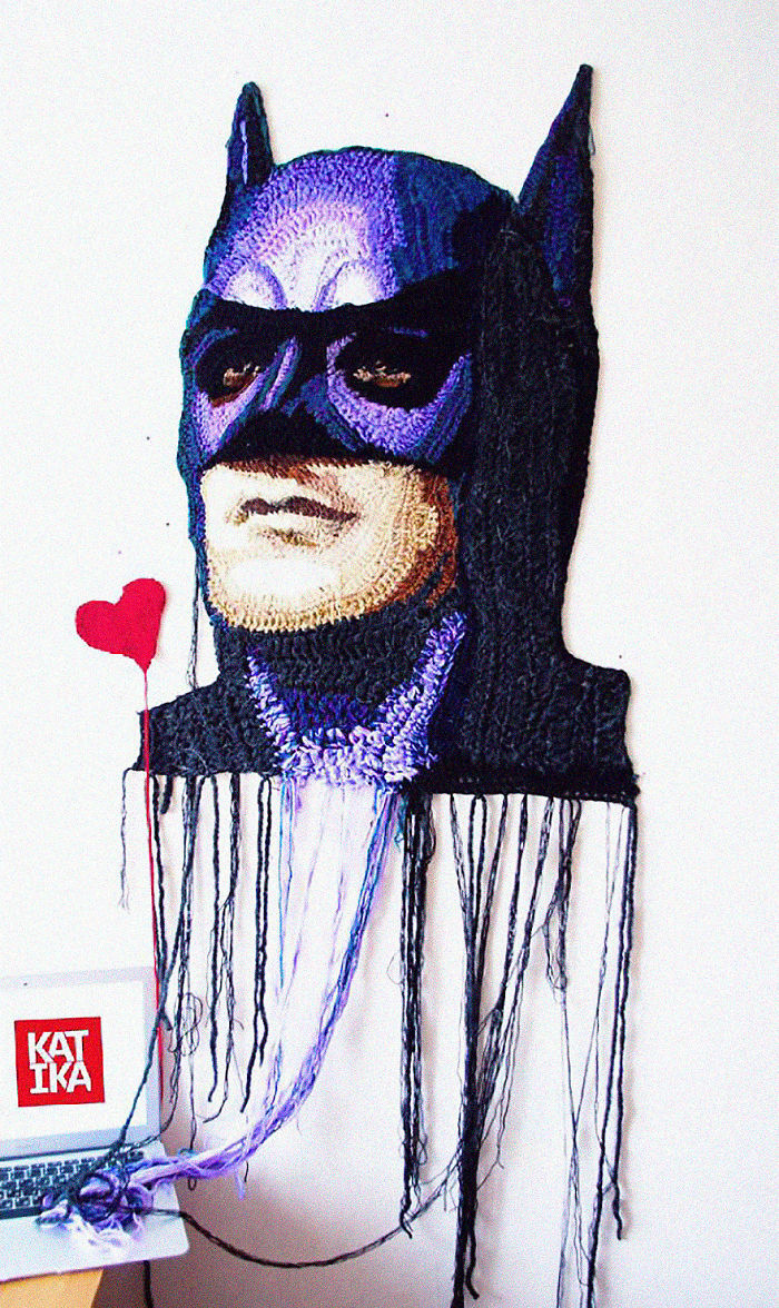Crochet artist portrait of a superhero with detailed stitching and hanging yarn strands, showcasing creative crochet art.