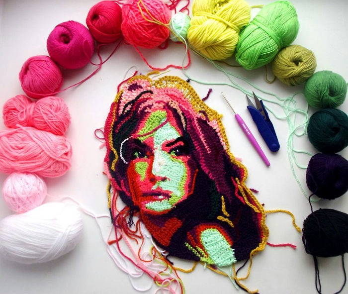 Colorful crochet portrait surrounded by yarn balls and crochet hooks, showcasing crochet artist's detailed yarn art.