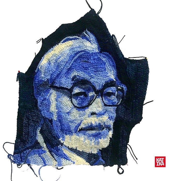 Crochet artist's detailed portrait of an elderly man with glasses, crafted with blue and white yarn.