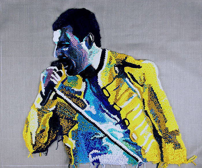 Crochet portrait of a singer wearing a yellow jacket, showcasing detailed yarn art by a crochet artist.