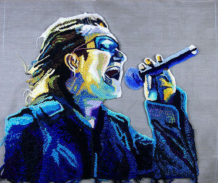 Crochet portrait of a singer holding a microphone, showcasing vibrant colors and intricate stitching by a crochet artist.