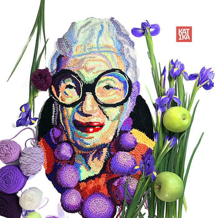 Colorful crochet portrait of a woman with glasses, surrounded by yarn and purple flowers, showcasing crochet art skills.