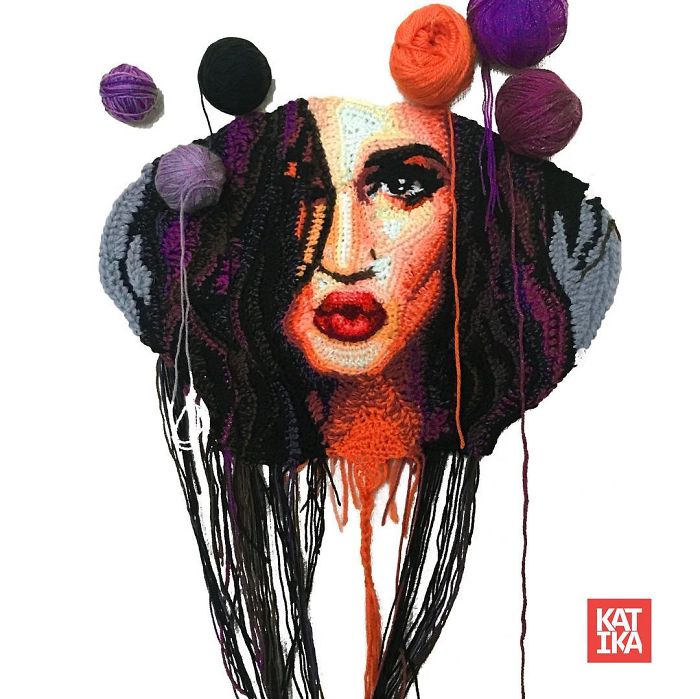 Crochet artist portrait of a woman with dark hair and red lips, surrounded by colorful yarn balls on a white background.