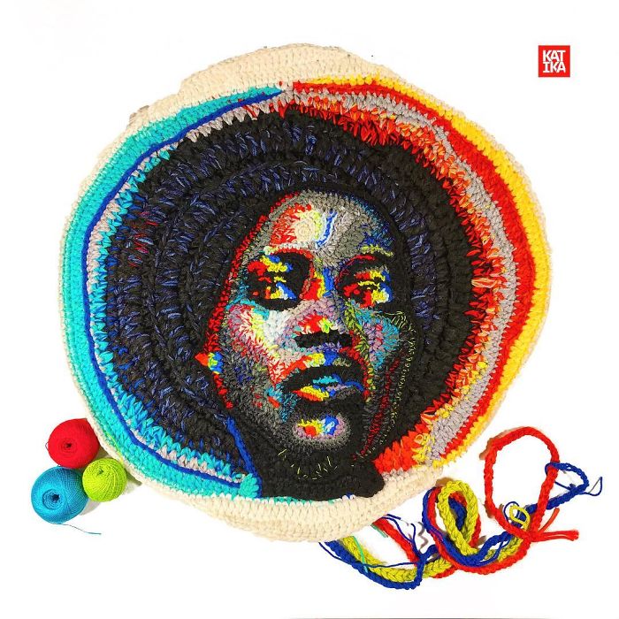 Crochet artist made colorful yarn portrait of a person with afro surrounded by bright multicolor crochet stitches.