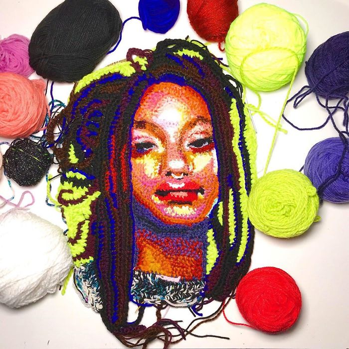 Crochet portrait of a woman with colorful yarn balls surrounding the detailed handmade crochet artwork.
