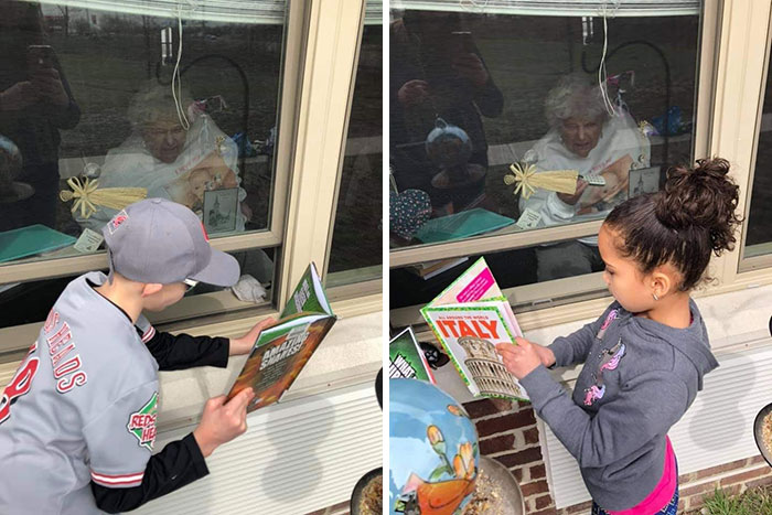Grandchildren Reading To Their Great Grandmother Through The Window Of Her Nursing Home