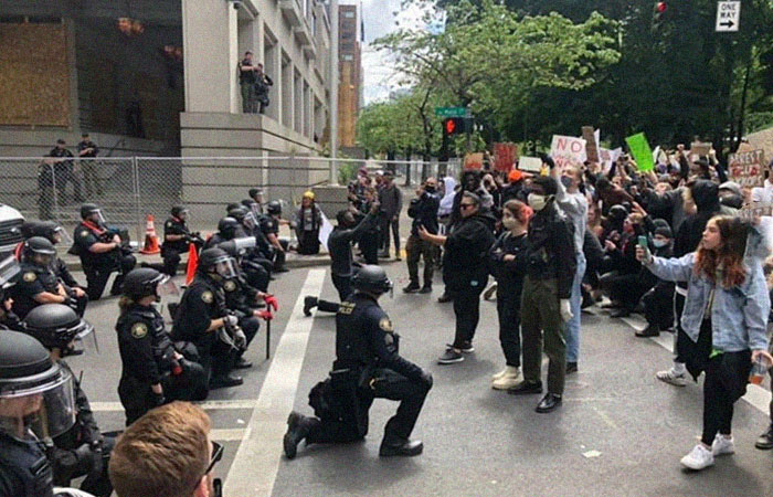 Policía de Portland arrodillándose frente a los manifestantes