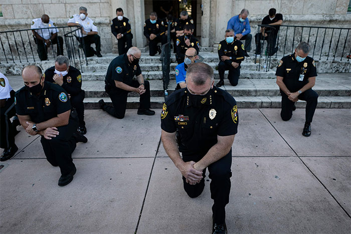 Police Officers Kneel During A Rally