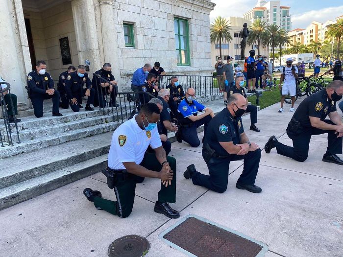 Policía de rodillas con los manifestantes en Miami