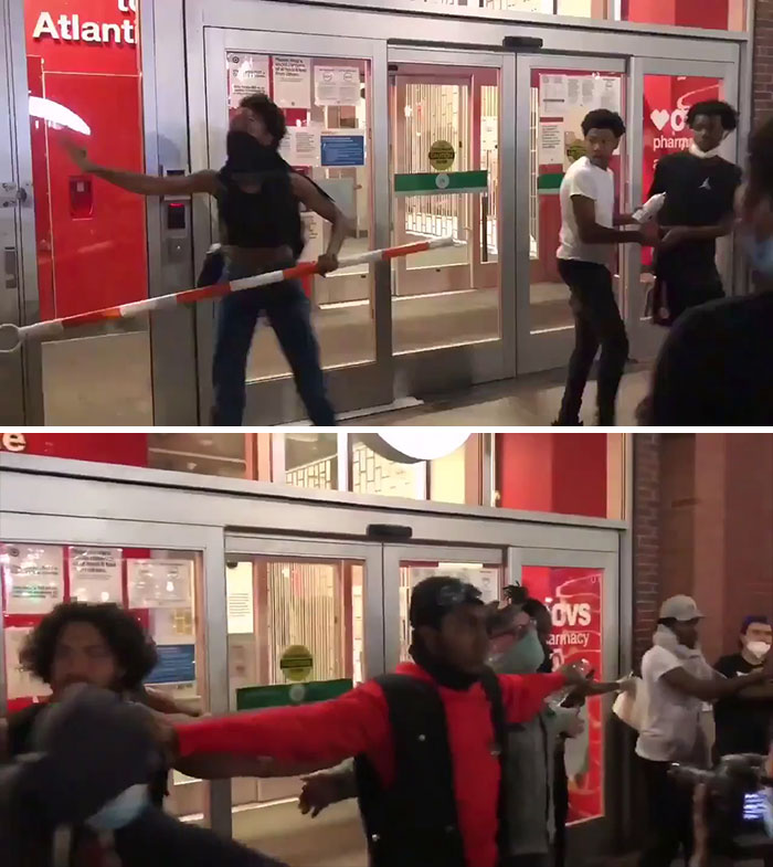 A Group Of People Forming A Human Barricade And Protecting The Store To Prevent People From Looting